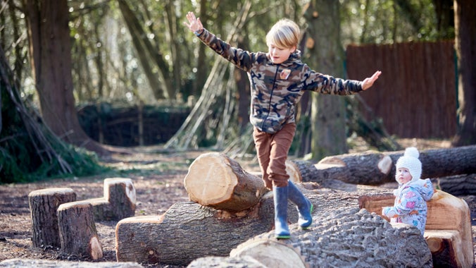 Children exploring the wild play area at Dyffryn Gardens, Cardiff, Wales.